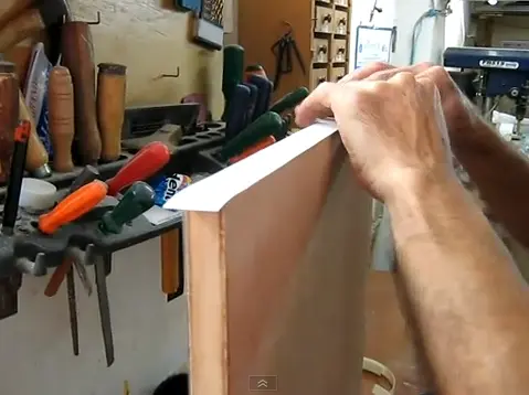 Proceso manual de enchapado de cantos, un trabajo que el servicio industrial de Ferrenova automatiza para un acabado perfecto.