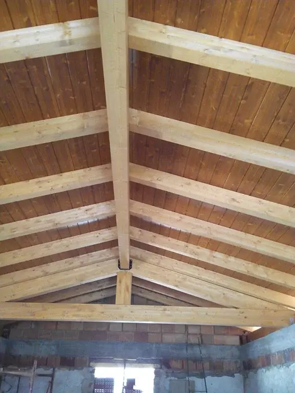 Estructura de techo en construcción, mostrando las correctas medidas de vigas de madera para techos suministradas por Ferrenova.