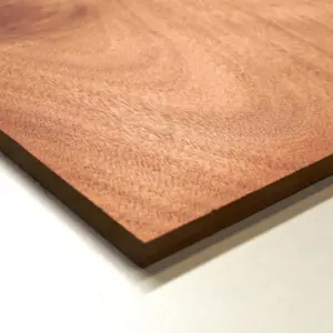 Detalle de un tablero de MDF con un enchapado de madera de tono rojizo, un material de alta calidad para el servicio de corte de madera a medida en Santiago.