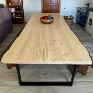 Mesa de comedor rústica moderna con tablones de madera a medida de pino o similar, destacando el canto vivo y patas metálicas, un proyecto con madera de Ferrenova.