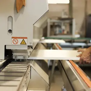 Operario de Ferrenova usando la máquina canteadora industrial para finalizar un tablero, parte del servicio de Corte de Aglomerado a Medida.