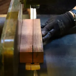 Operario de Ferrenova realizando un corte limpio y preciso en un listón de madera dura, parte del servicio de Corte de Madera.