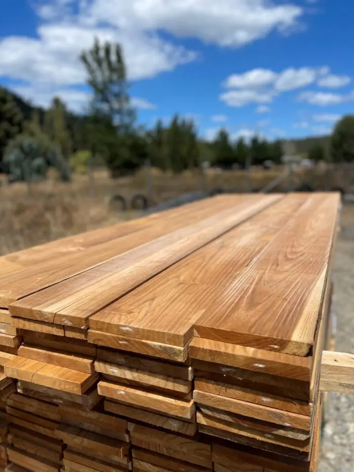 Pila de tablones de madera nativa cepillada, listos para el servicio de corte de tablones de madera a medida de Ferrenova.