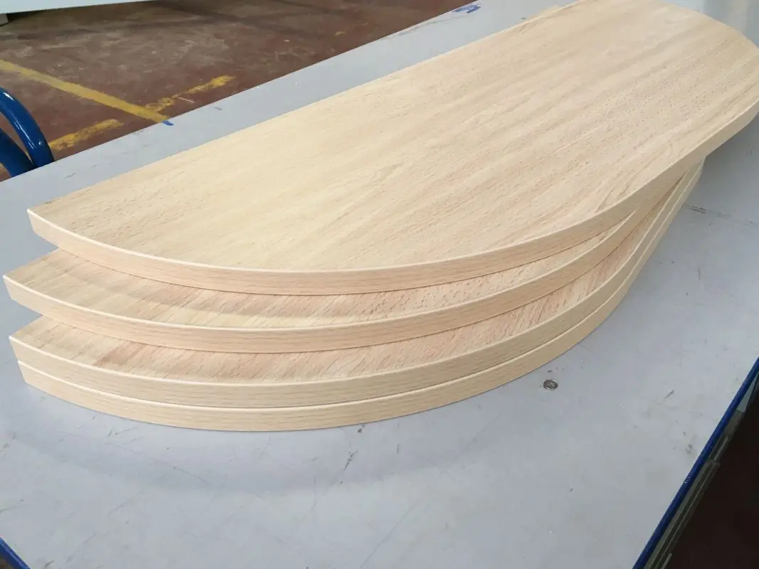Piezas de melamina con canteado de madera en curva, mostrando el servicio de precisión en radios de Ferrenova.