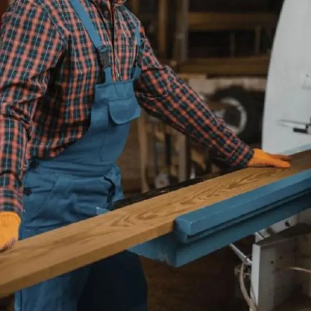 Operario de Ferrenova aplicando tapacanto a un tablero de madera, parte del servicio de corte y canteado de tableros.
