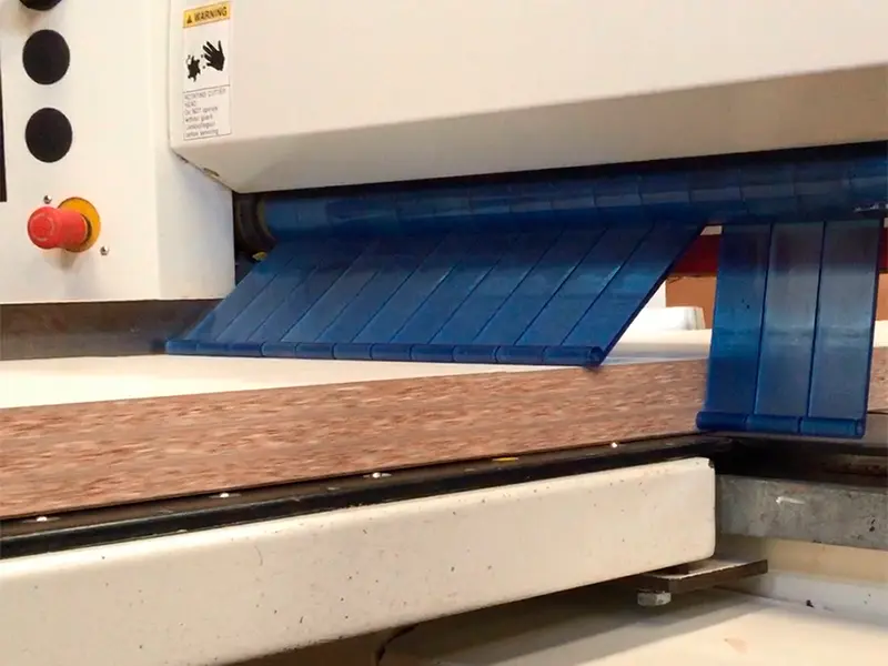 Máquina industrial realizando el corte de aglomerado a medida en Ferrenova, asegurando precisión.