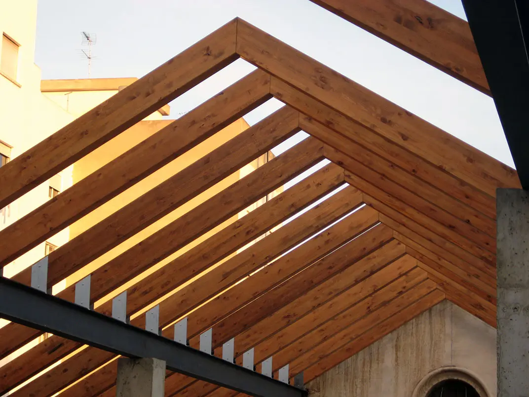 Detalle de estructura de techo a dos aguas, mostrando las correctas medidas de vigas de madera para techos de Ferrenova apoyadas en conectores metálicos.