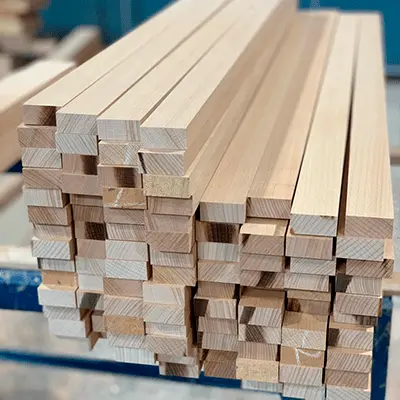 Pila de listones de madera perfectamente cortados, resultado del servicio de dimensionado profesional de Ferrenova.