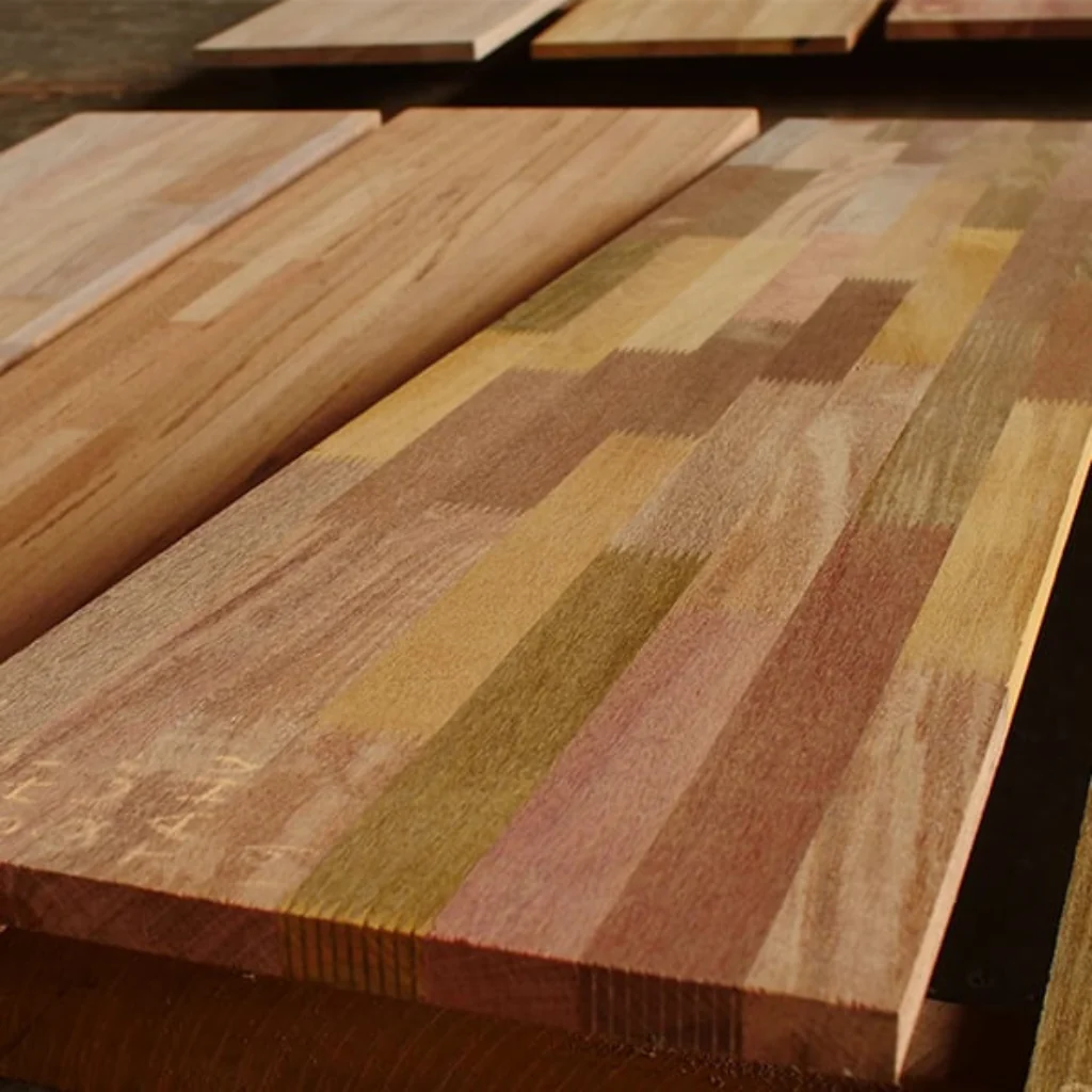 Tablero de madera con franjas verticales de tonos claros y oscuros, mostrando un producto fabricado con cortes de pino a medida.