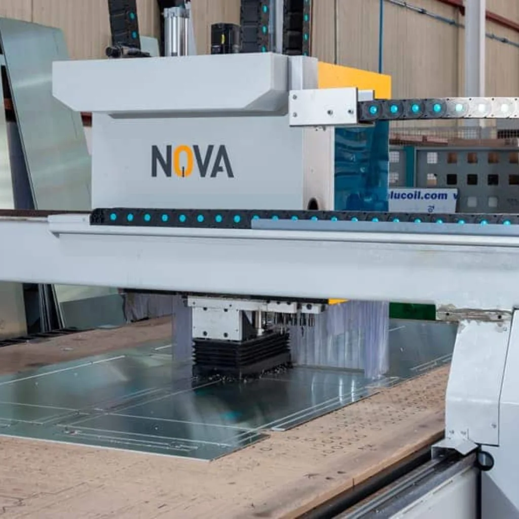 Operario supervisa CNC mecanizando tablero para fenólico a medida con cortes precisos.