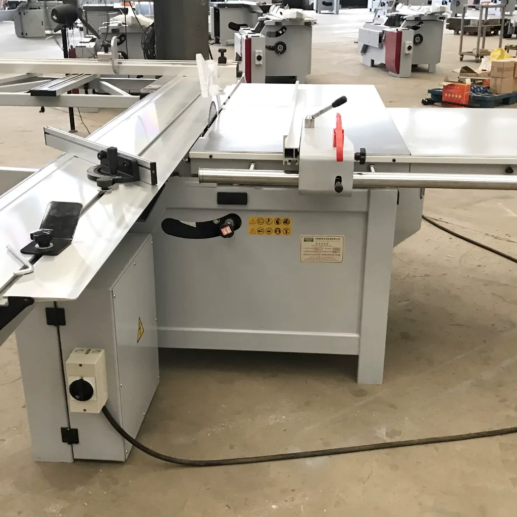 Sierra escuadradora con mesa deslizante en taller, utilizada para el corte preciso de tableros HPL a medida, con guía y tope calibrados.